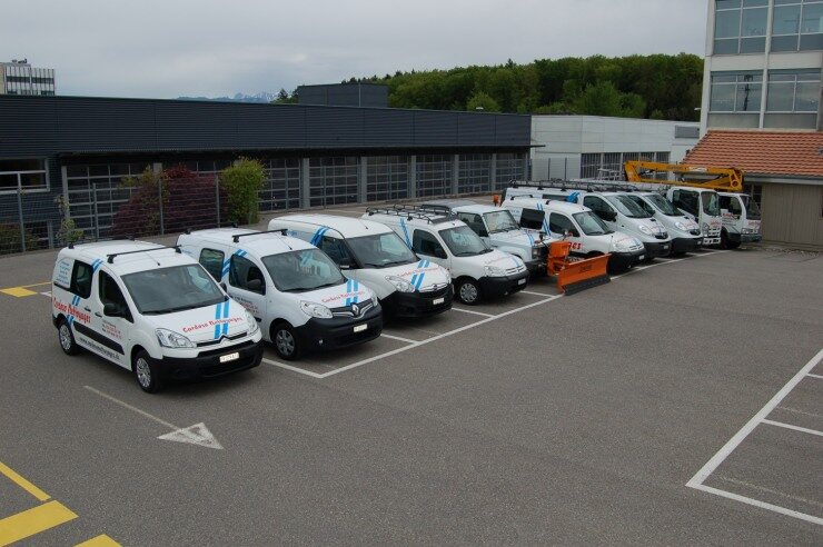 Vue aérienne de la flotte de véhicules Cardoso Nettoyages alignés sur le parking de l’entreprise