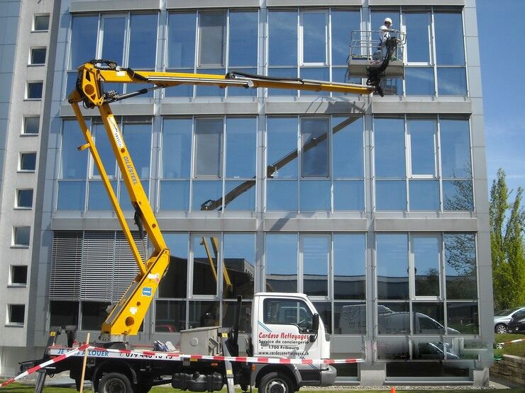 Camion-nacelle en action le long d’une façade vitrée