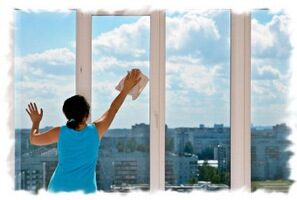 Nettoyage d’une grande fenêtre au chiffon, ciel bleu en arrière-plan